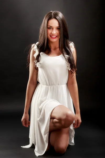 Mulher bonita em vestido branco no fundo preto — Fotografia de Stock