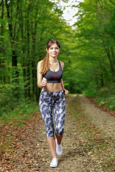 Bastante joven corredor en el bosque. — Foto de Stock