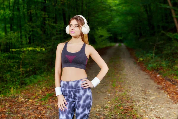 Relaxing runner resting and listening to music on headphones in — Stock Photo, Image