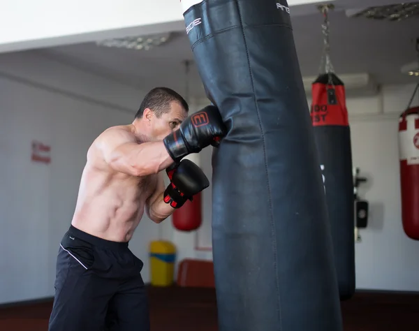 Treinamento de kickboxer no ginásio chutando o saco de soco — Fotografia de Stock