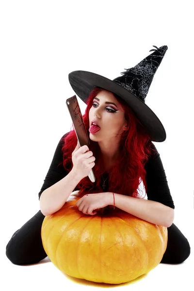 Witch with bloodstained hands with a hatchet in hand sits on a p — Stock Photo, Image