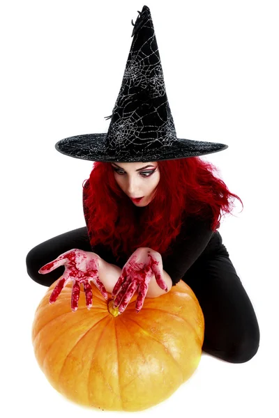 Strega con le mani macchiate di sangue siede su una zucca — Foto Stock