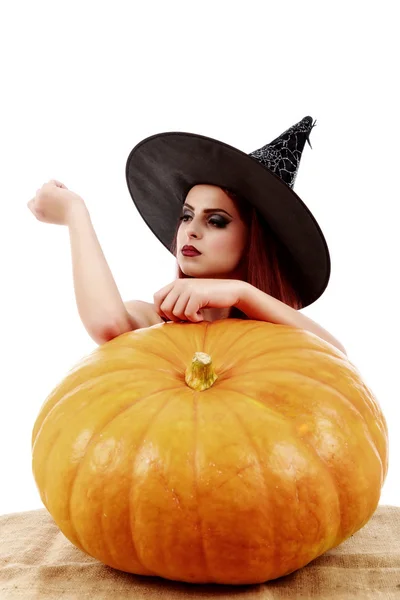 Beautiful red-haired witch casts a spell over pumpkins. Hallowee — Stock Photo, Image