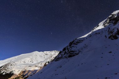 Dağlar ve mavi gökyüzü ile kış gecesi manzara