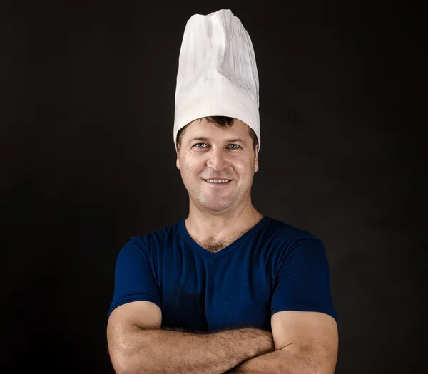 Okouzlující šéfkuchař pózuje na černém pozadí — Stock fotografie