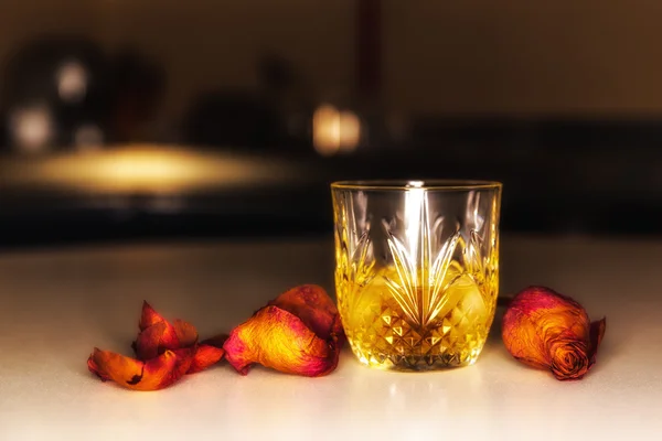 Kieliszek whisky na stole z różą — Zdjęcie stockowe