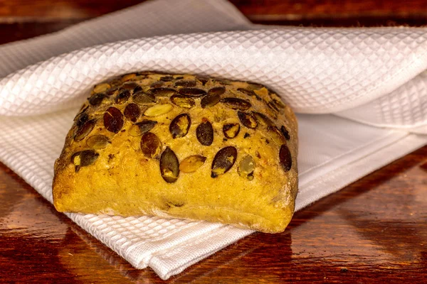 Brötchen mit Sonnenblumenkernen auf Holztisch — Stockfoto