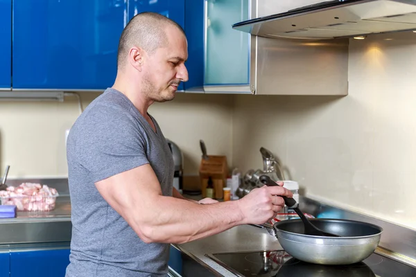 Jóképű férfi otthon a konyhában főzés — Stock Fotó