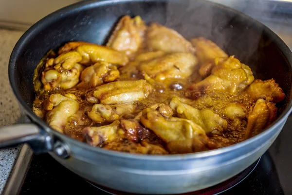 Asiático caramelizado pollo alas cocinar en un wok —  Fotos de Stock