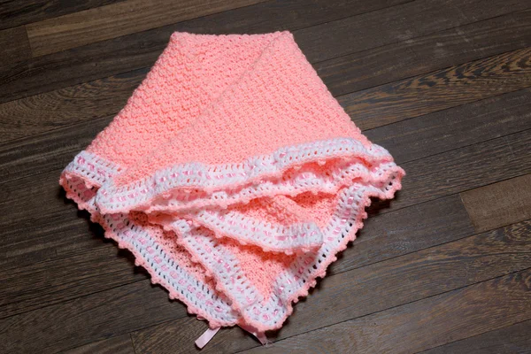 Handmade baby blanket isolated on wood — Stock Photo, Image