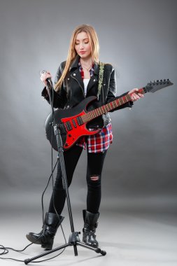 Genç, sarışın güzel kadın bir elektro gitar ile