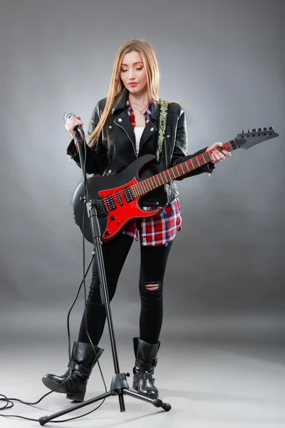 Hermosa mujer joven y rubia con una guitarra eléctrica — Foto de Stock