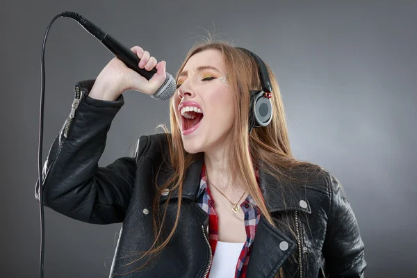 Žena s sluchátka a mikrofon zpěv — Stock fotografie