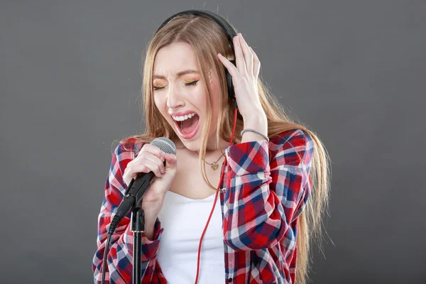 Donna con cuffie e microfono che canta — Foto Stock