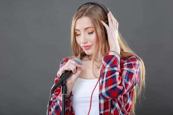 Donna con cuffie e microfono che canta — Foto Stock