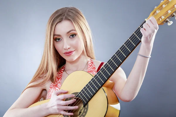 Eine schöne junge Blondine mit einer klassischen Gitarre — Stockfoto