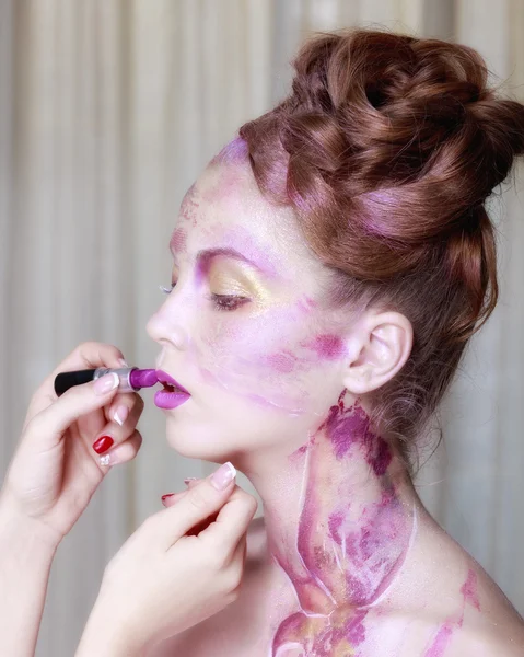 Makeup artist applies lipstick. Beautiful woman face. Perfect ma