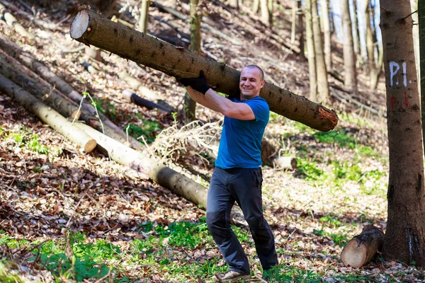 Güçlü adam bir ağaç gövdesi taşıyan — Stok fotoğraf