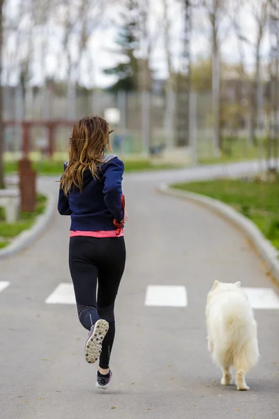 attractive sport girl running with dog in park