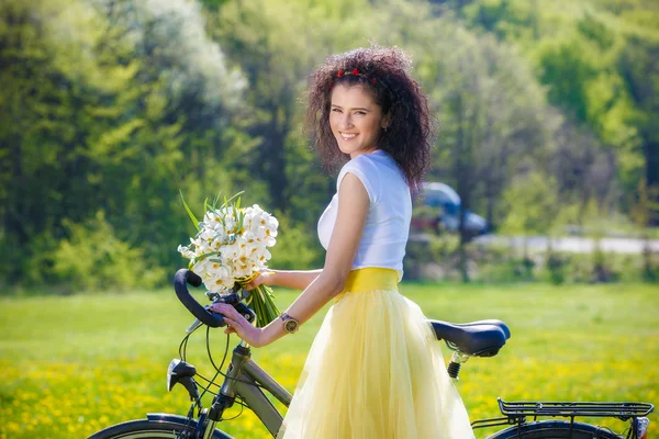 Όμορφη νεαρή γυναίκα με ένα ποδήλατο στη φύση — Φωτογραφία Αρχείου