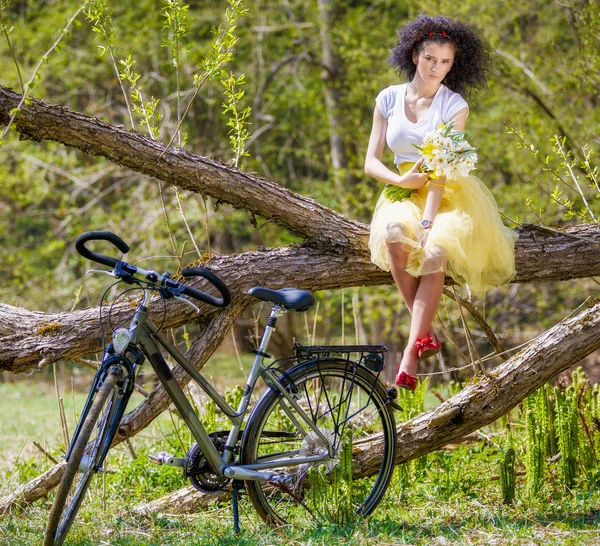 Beautiful young woman with a bicycle in nature — Stock Photo, Image