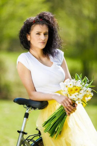 Beautiful young woman with a bicycle in nature — Stock Photo, Image