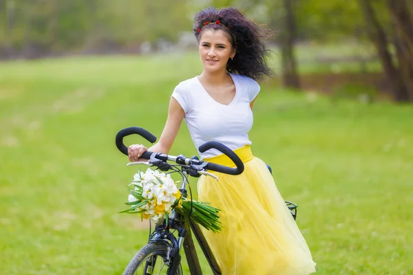 Hermosa joven con una bicicleta en la naturaleza — Foto de Stock