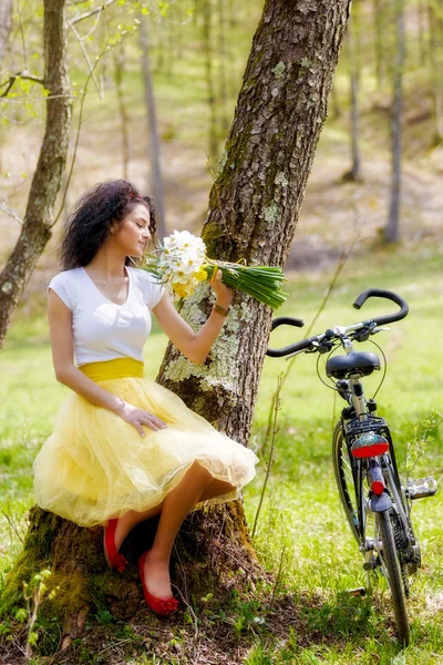 Hermosa joven con una bicicleta en la naturaleza — Foto de Stock