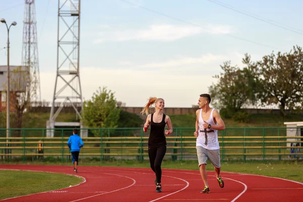 Un homme et une femme attirants jogging sur la piste — Photo