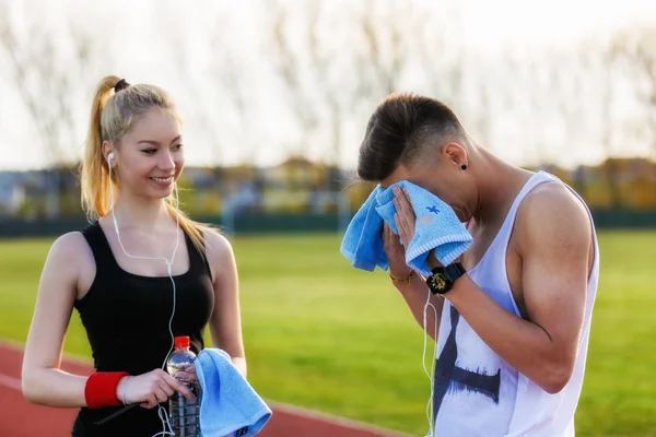 Una hermosa pareja joven descansando después de correr — Foto de Stock