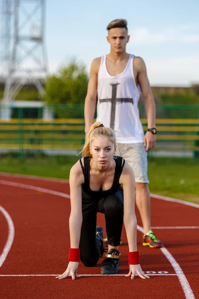 Pareja deportiva joven en posición inicial preparada para competir y — Foto de Stock