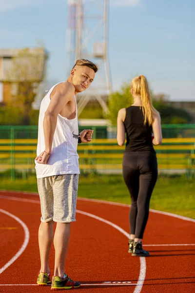 Un homme et une femme attirants jogging sur la piste — Photo