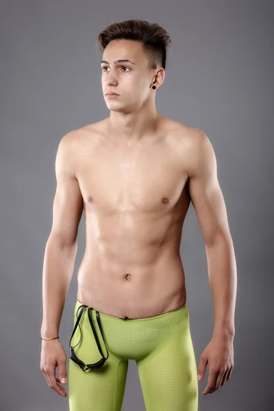 灰色の背景に水泳ゴーグルを持つ若者の肖像 — ストック写真
