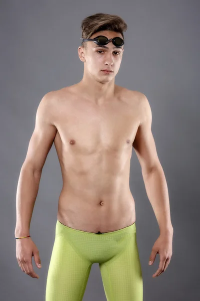 Porträt eines jungen Mannes mit Schwimmbrille auf grauem Hintergrund — Stockfoto