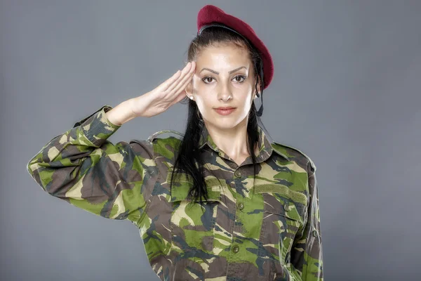 Mulher soldado do exército saudando isolado em fundo cinza Imagem De Stock