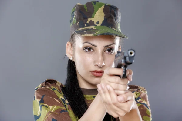 Soldat féminin en uniforme de camouflage avec arme isolée sur fond gris — Photo