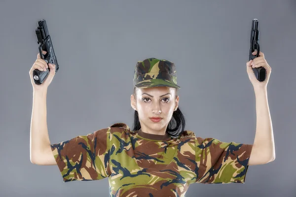 Soldato donna in uniforme mimetica con arma isolata su sfondo grigio — Foto Stock