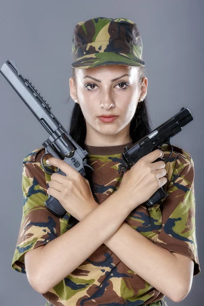 Soldat féminin en uniforme de camouflage avec arme isolée sur fond gris — Photo