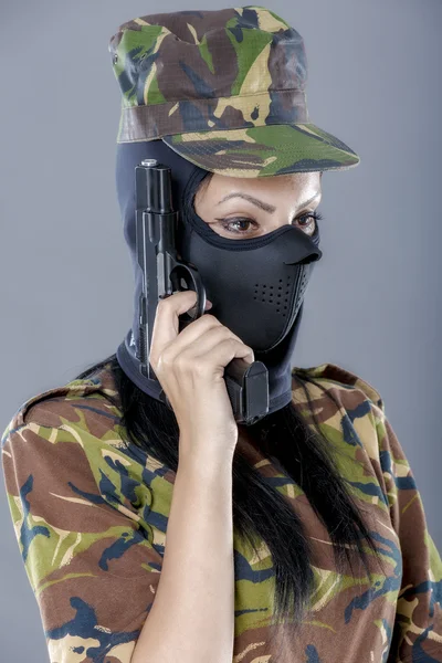 Soldat féminin en uniforme de camouflage avec arme isolée sur fond gris — Photo