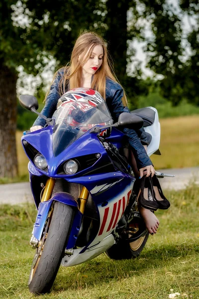 Beautiful young woman with a motorcycle speed in nature — Stock Photo, Image