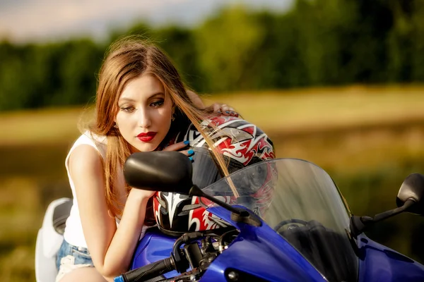 Όμορφη νεαρή γυναίκα με μια ταχύτητα μοτοσικλέτας στη φύση — Φωτογραφία Αρχείου