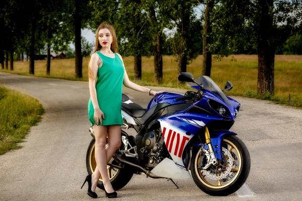 Belle jeune femme avec une vitesse de moto dans la nature — Photo