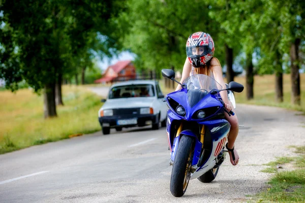 Beautiful young woman with a motorcycle speed in nature — Stock Photo, Image