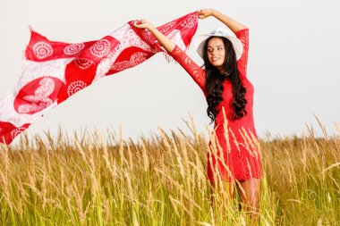 Günbatımında bir alanda bir eşarp ile güzel esmer kadın