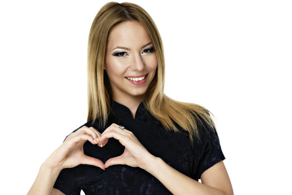 Счастливая улыбающаяся молодая женщина с символическим жестом сердца
