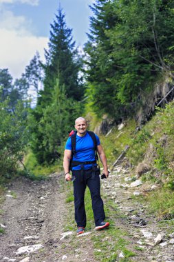 bir dağ yolunda yürüyen turist