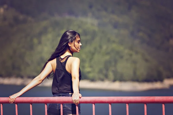 Uma bela jovem posando em uma ponte — Fotografia de Stock