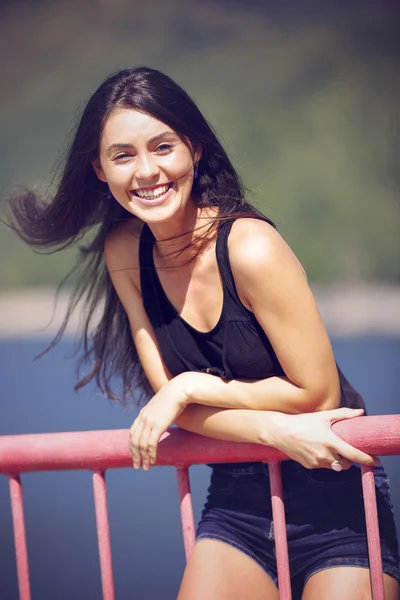 A beautiful young woman posing on a bridge — Stock Photo, Image
