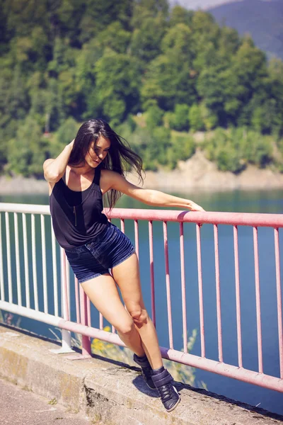 Una hermosa joven posando en un puente — Foto de Stock