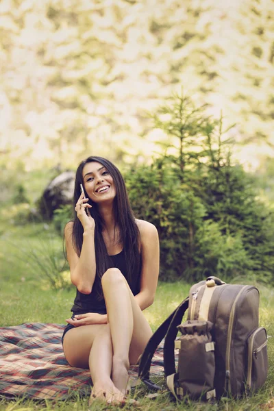 En vacker ung kvinna sitter på en picknick i naturen och användningsområden t — Stockfoto